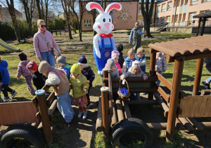 dzieci znajdują koszyk w wagonikudrewnianego pociągu w ogrodzie