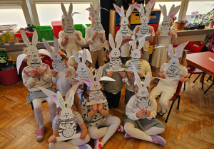 przedszkolaki z zajączkami zdobiącymi przedszkole