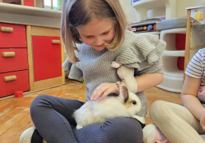 dziewczynka głaszcze królika