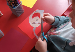 dziecko wycina głowę lalki