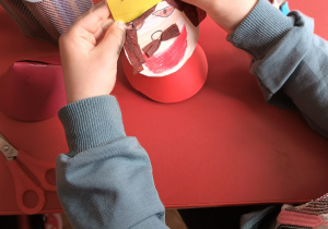 dziecko dokleja koronę lalce