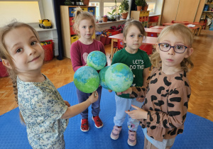 dziewczynki trzymają Ziemie - wykonane z balonów pomalowanych farbami