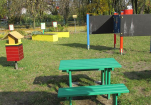 tablice do rysowania i ławeczki ze stolikiem w ogrodzie przedszkolnym