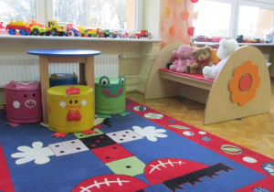 sala, kącik relaksacyjny z kolorowym dywanem i maskotkami