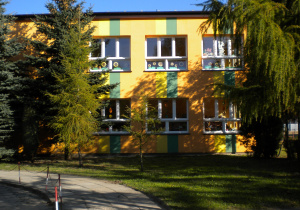 widok budynku przedszkola wśród drzew od strony wejścia na teren placówki