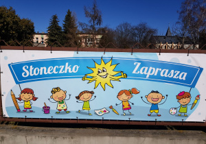 baner przedszkola z napisem "Słoneczko zaprasza", logo placówki i dziećmi z kredkami i farbami